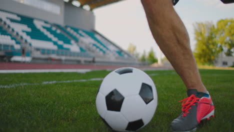 Close-up-of-a-male-soccer-player-running-with-a-soccer-ball-on-the-football-field-in-the-stadium-demonstrating-excellent-dribbling
